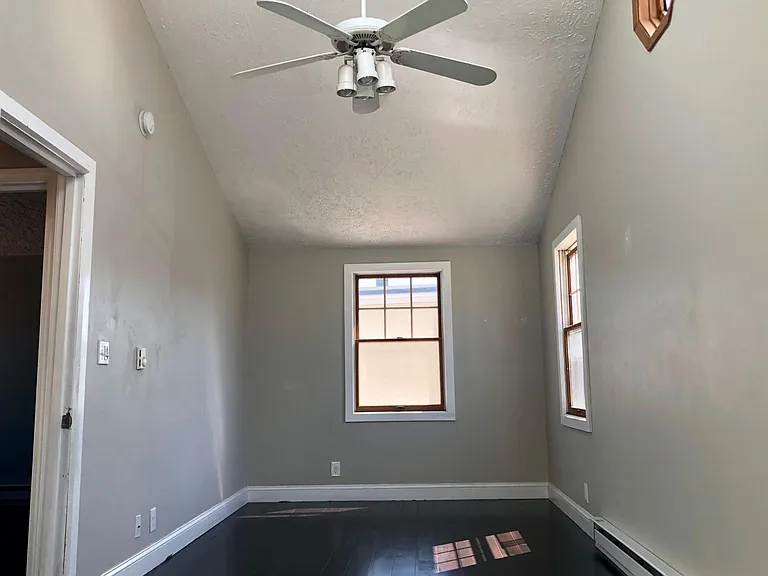 one of the 2 third floor bedrooms with cathedral ceilings and a ceiling fan.