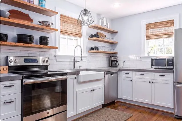 Updated kitchen with concrete counters, stainless appliances, open reclaimed wooden shelves, and farmhouse sink. Coffee maker, microwave oven, toaster, pots pans, and all dishes provided.