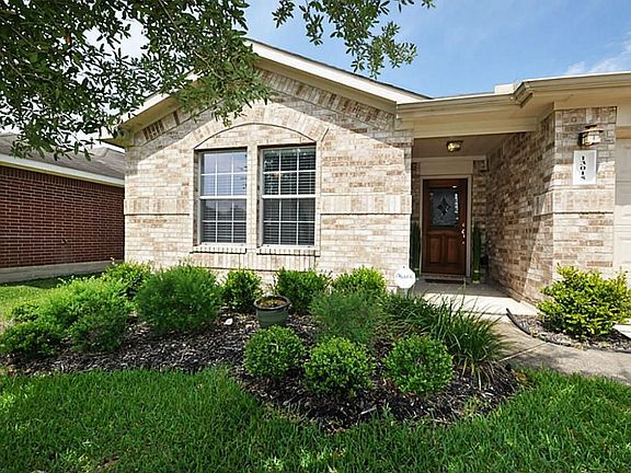 Custom landscaping greets you as you approach the covered entrance.