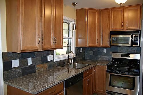 Sleek renovated kitchen includes maple cabinets, granite counters, SS appliances and new tile floors