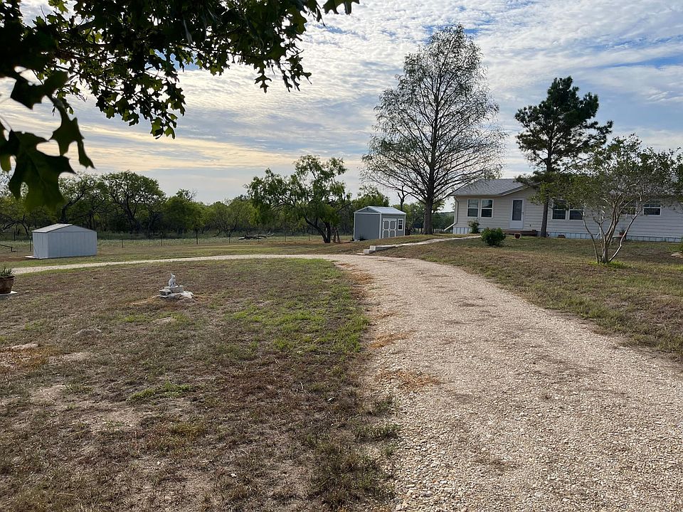 Circular drive front of house. Storage shed to the right and pump house lower left.