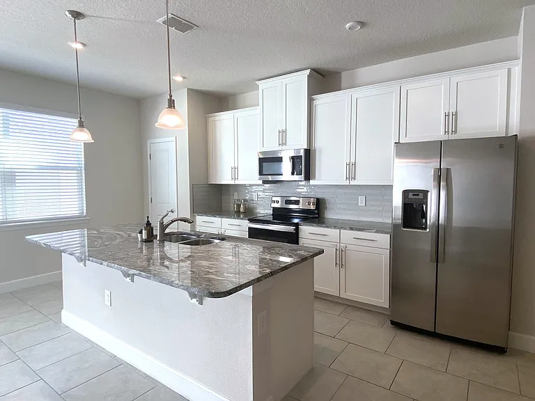 Kitchen with marble granite counter top, titled backsplash, all stainless steel appliances, all soft close drawers