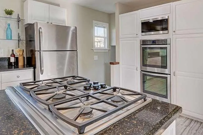 Gas cooktop with two ovens, microwave, retractable exhaust v