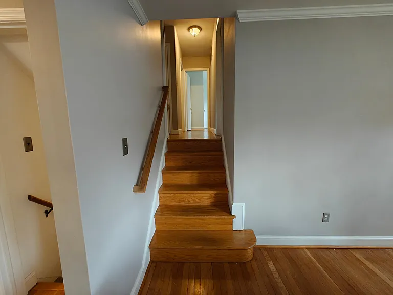 Stairway up to Bedrooms 3, 4, and Office and Master Bedroom and interior garage access. Stairway down goes to family room.