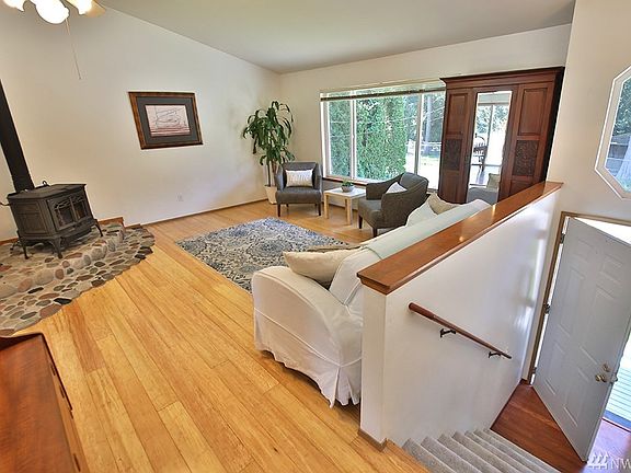 Bamboo floors reflect the warmth & light of this spacious main living room. Custom fieldstone hearth has a secret rock hiding spot.  Quality double paned windows provide ample light even on the grayest of days. 
