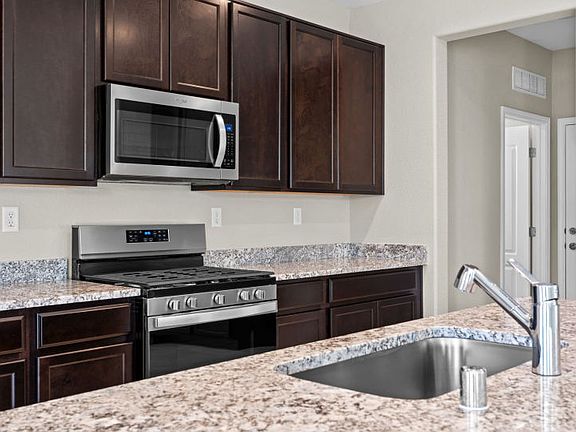Kitchen layout featuring granite and stainless steel appliances.