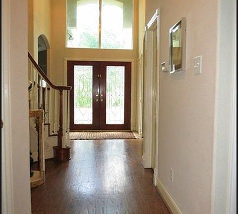  Dramatic two story entry with wood floors and double lead glass front doors.