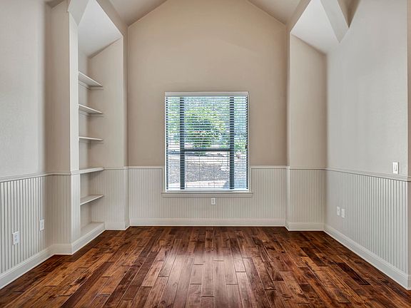 Formal Living room with built in shelves. Large window.