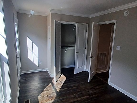 Bedroom with closet and door leading to backyard. Dimensions 12'8" x 9'2"