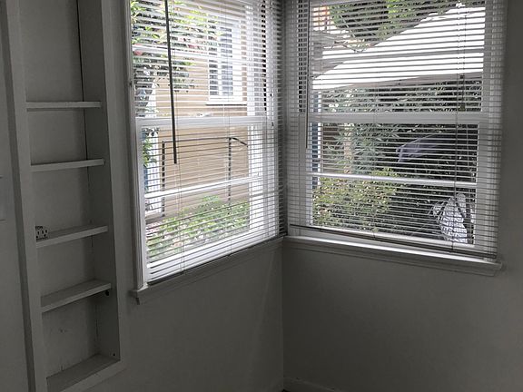 Corner of kitchen, which is light-filled, windows look out on patio area.