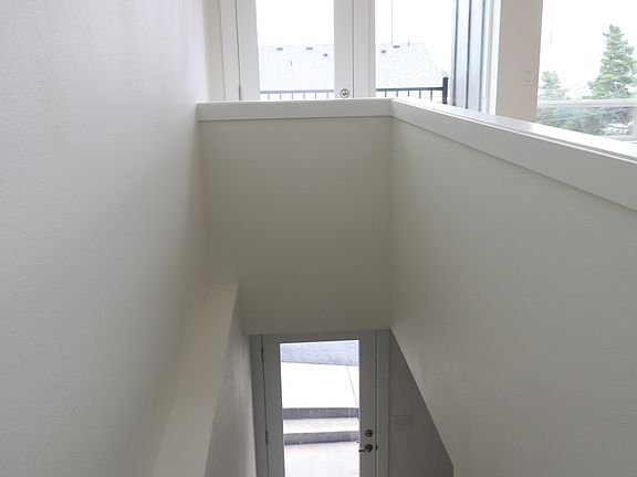 Front door and stairs up to main living area with Balcony