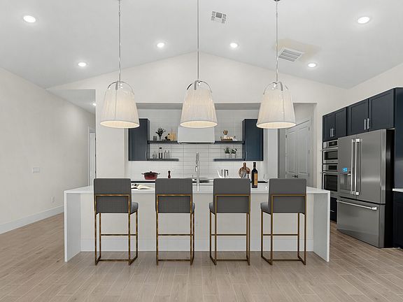 Kitchen with pendant lighting and waterfall edge island