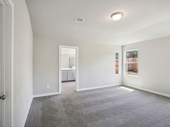 A primary bedroom in a home in Stewart s Ranch of Conroe, TX.