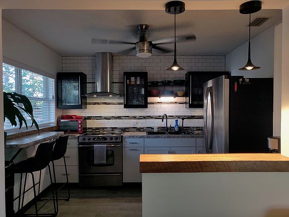 Modern kitchen includes cookware, dishes, etc.