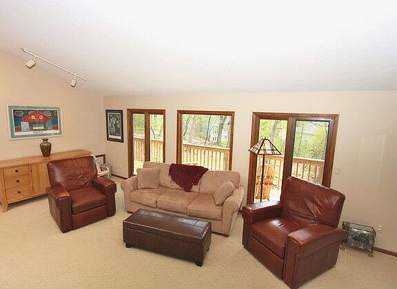 Large living room w/wood fireplace & nature views.