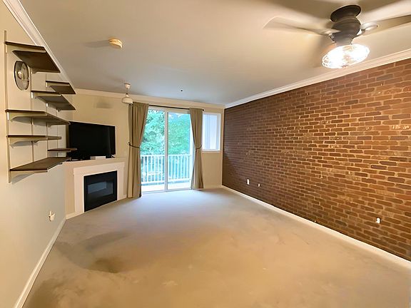A living room with high ceilings and a ceiling fan, providing comfort even in the summer.