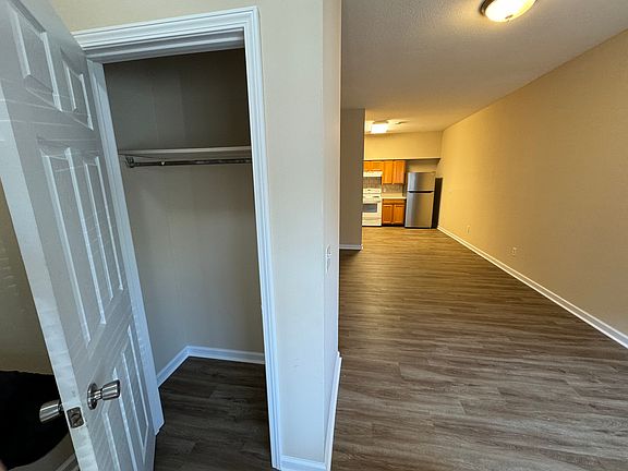From front door looking passed coat closet, through living room towards kitchen