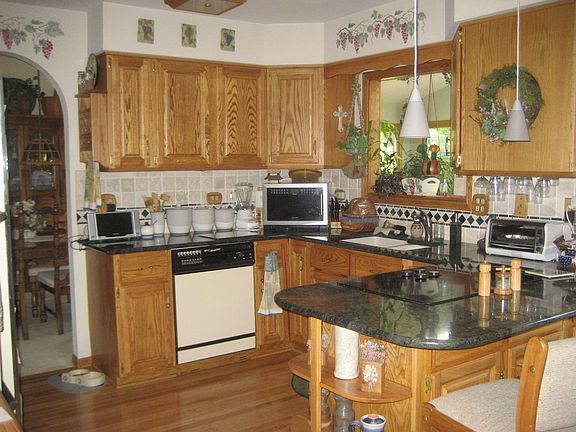 Remodeled kitchen with hardwood floor, breakfast bar & granite countertops
