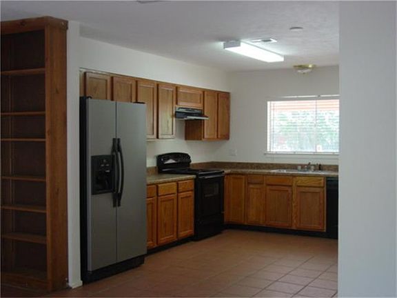 View of Kitchen from Living Room Open and Bright Tile Flooring thru out with built in bookcase