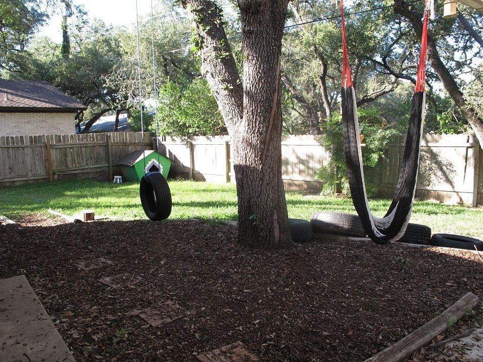 nice fenced in backyard with large trees
