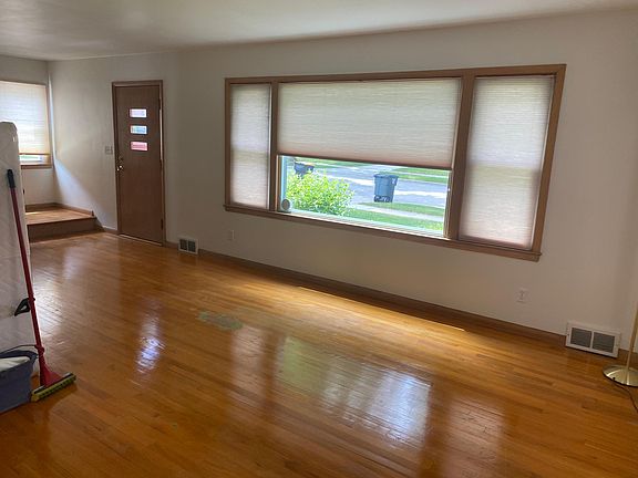 Living room with large windows. All windows have window coverings/sheers for privacy