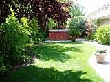 Private backyard beautifully landscaped with meandering pathways, mature trees