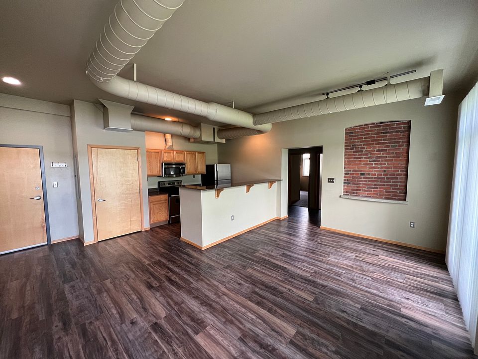 Open floor plan featuring wood floors and brick detail