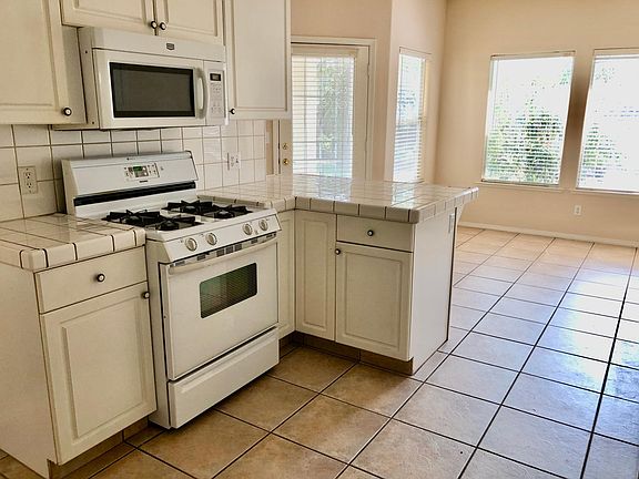 Gas stove and oven and kitchen eating area looking to the back yard