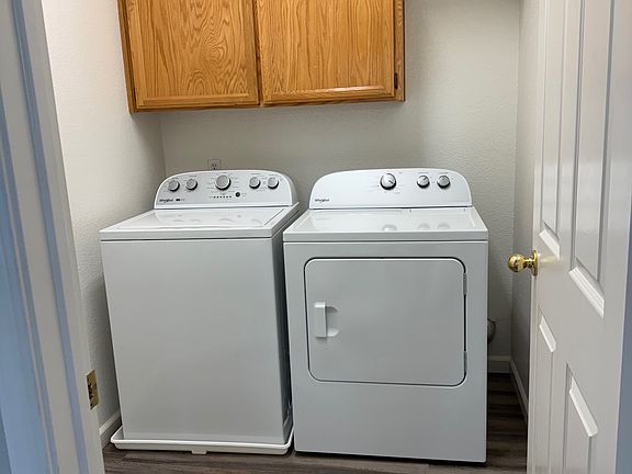Separate laundry room with door - matching new Whirlpool washer and newer dryer.