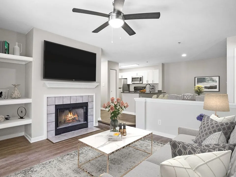 Renovated living area with a fireplace and ceiling fan at The Crossings at Russett in Laurel, MD