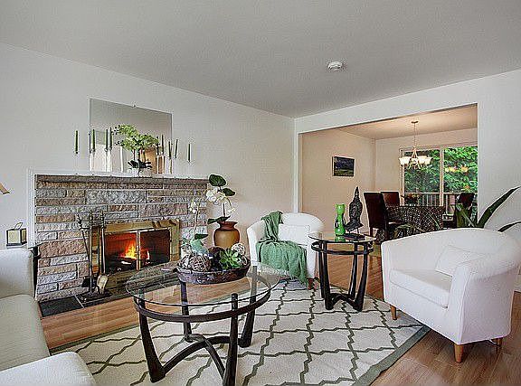 Living room shows fireplace and entry to dining room with slider doors to deck.