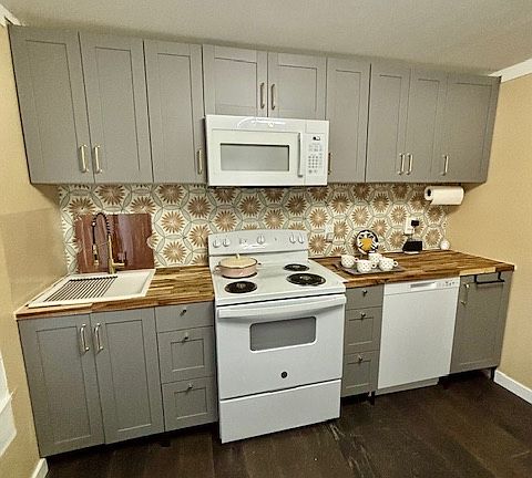 New cabinets, an over-the-range microwave, a full-size dishwasher and refrigerator, two-function faucet sprayhead, a porcelain backsplash, and butcher block countertops await.