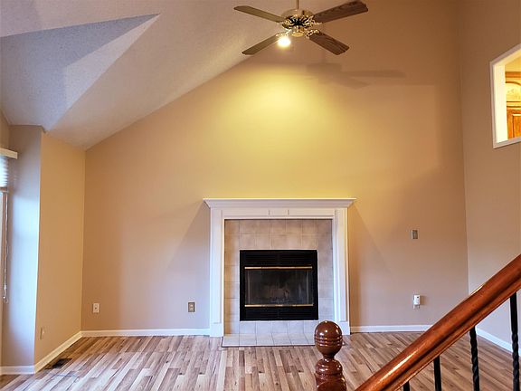 entry level famly room with fireplace and vaulted ceiling