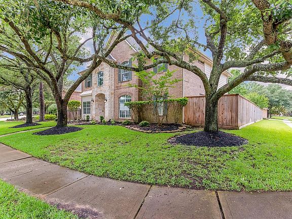 Mature trees adorn the lot enhancing the curb appeal of this brick and stone exterior home!