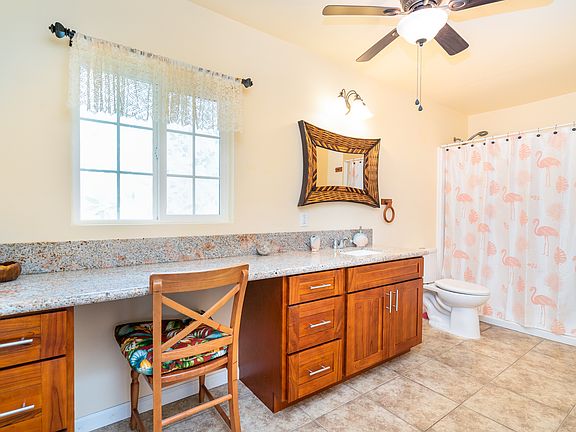 Extra-large bathroom with full vanity, seated makeup area, generous counter space, and bright natural lighting.
