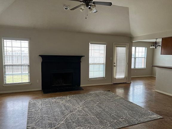 Open Family Room with fireplace, tall ceilings, connects into kitchen and overlooks back yard.