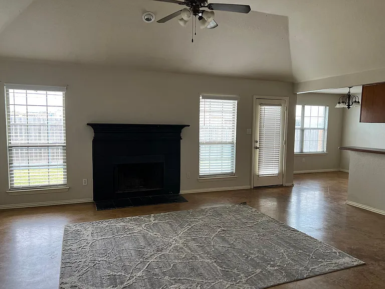 Open Family Room with fireplace, tall ceilings, connects into kitchen and overlooks back yard.