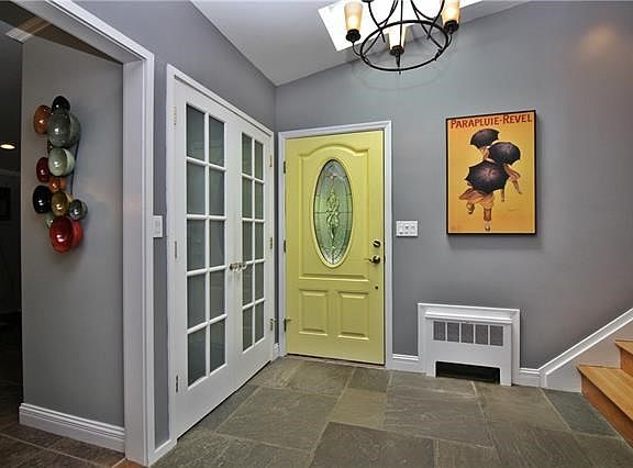 The spacious entry foyer with file flooring and skylight welcomes you into this incredible home.