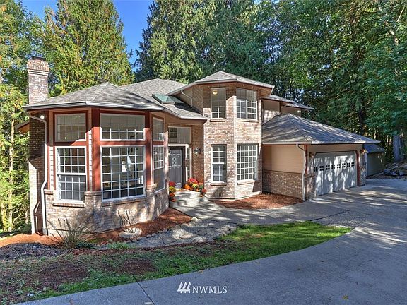 Situated on a shy acre lot and surrounded by nature. Long cement driveway leads to 3-car garage and ample parking space.