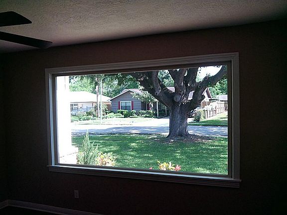 Huge picture window overlooks oak tree and front yard