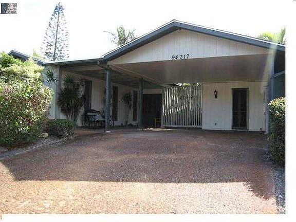 Front house, car port, pebbled stone driveway