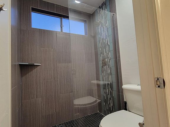 Downstairs bathroom. Renovated shower with beautiful glass tile accents, lighting that includes a built-in bluetooth speaker for relaxing or uplifting showers!