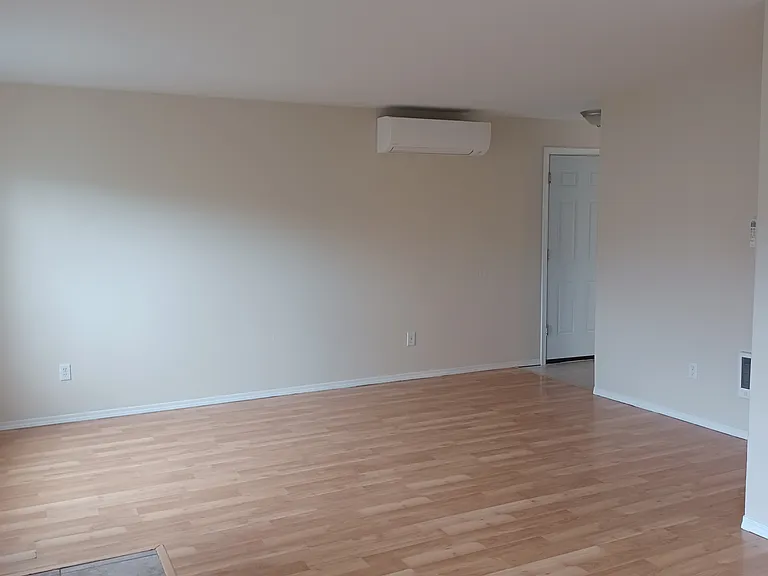 Living area with mini split and door to attached garage.