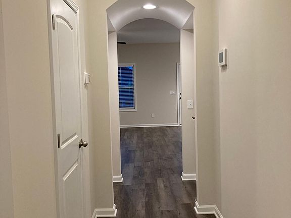 Hall leading from downstairs foyer into family room. Powder room on left.