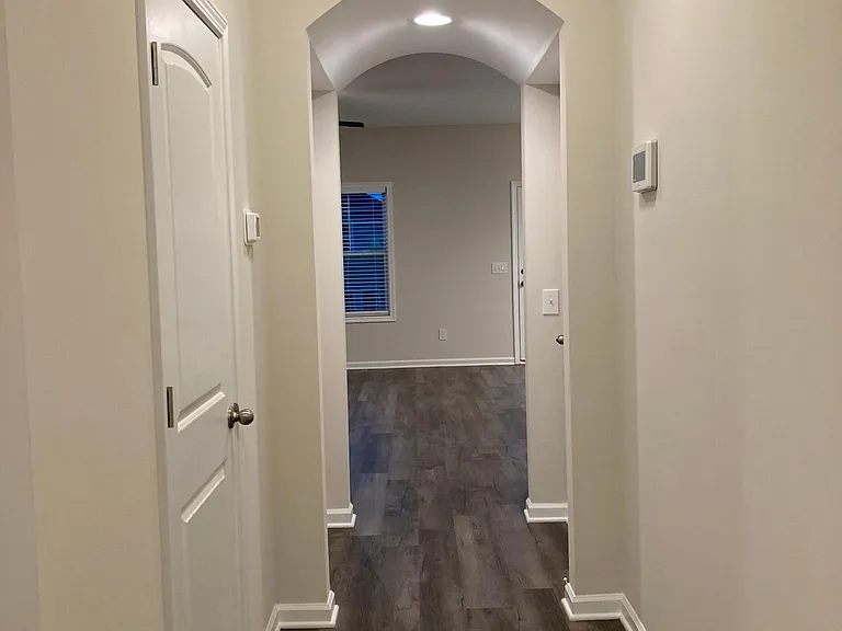Hall leading from downstairs foyer into family room. Powder room on left.