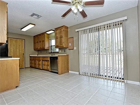 Kitchen with hard tile flooring, wood cabinets