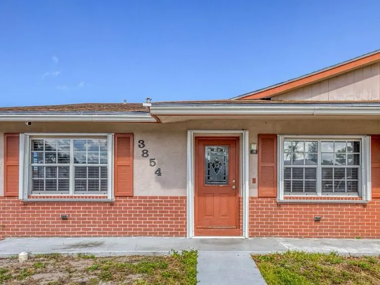 Home entrance with accordion hurricane shutters