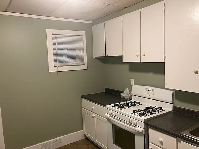 West side of kitchen with new window, counter, and lower cabinets