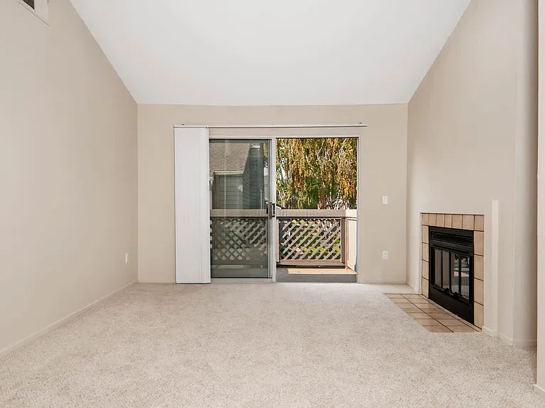Carpeted Living Room with Fireplace and Balcony