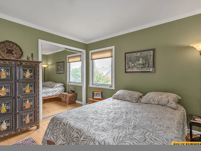 Second bedroom on the main level is furnished with a queen bed, desk and chair, large closet with sliding mirrored doors, dresser and floor lamp and has two windows and a corner desk with desk chair.